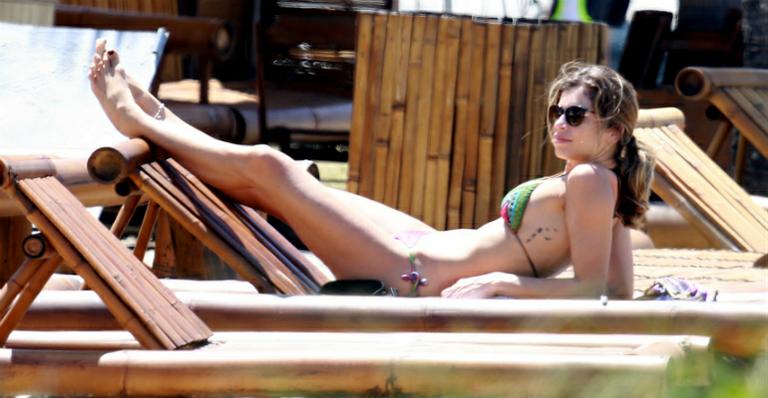 Grazi Massafera pratica exercícios e depois relaxa em praia no Rio