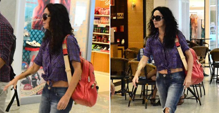 Aos 51, Claudia Ohana exibe barriga sarada no aeroporto