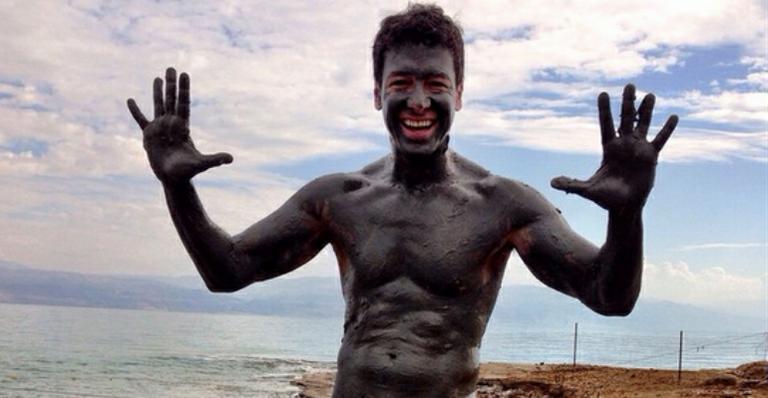 De sunga, Rodrigo Faro se cobre de lama em Israel