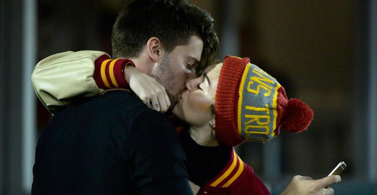 Miley Cyrus beija muito o filho de Arnold Schwarzenegger em jogo