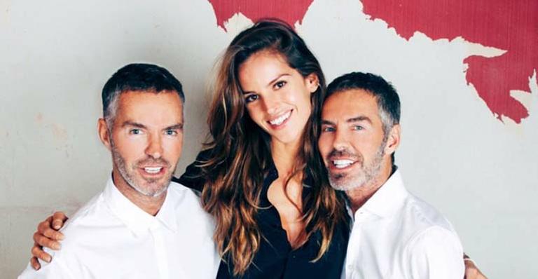 Izabel Goulart posa com estilistas Dean e Dan Caten em backstage de semana de moda masculina