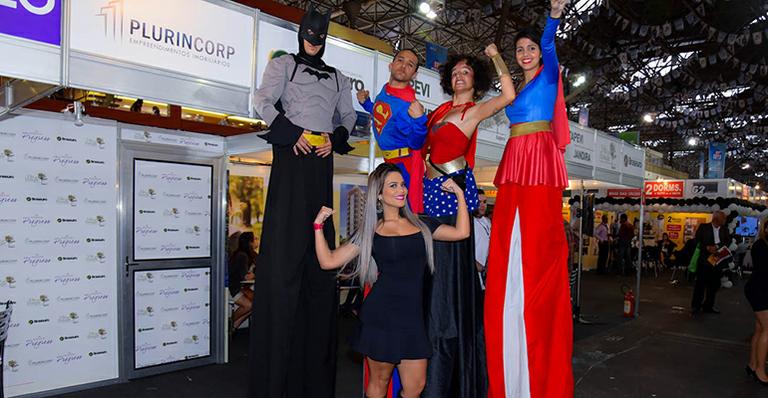 Em evento, Geisy Arruda posa e faz graça com super-heróis em pernas de pau