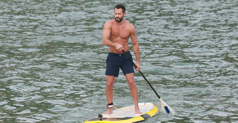 Malvino Salvador pratica stand up paddle na praia e exibe boa forma