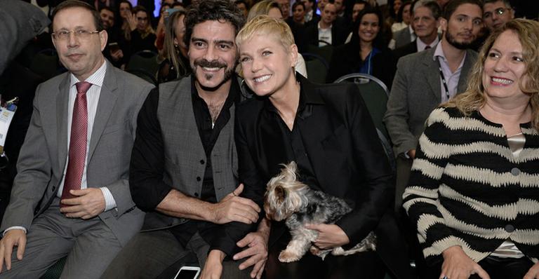 Xuxa e Junno Andrade levam cachorrinho em evento empresarial