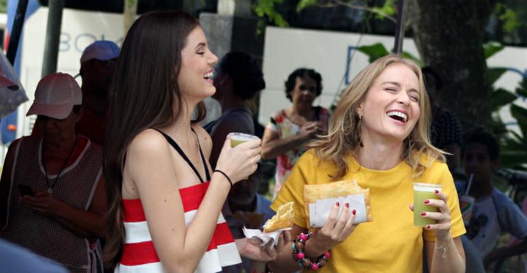 Angélica e Camila Queiroz comem pastel de feira em gravação