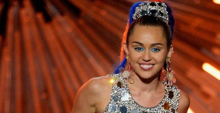 Em foto, Miley Cyrus aparece tomando mamadeira no colo da mãe