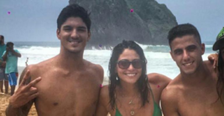 Em Noronha, Carol Castro posa ao lado dos surfistas Gabriel Medina e Filipinho