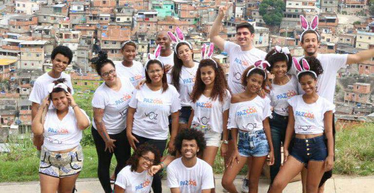 Marcelo Adnet e Hugo Bonemer distribuem chocolate no complexo do Alemão