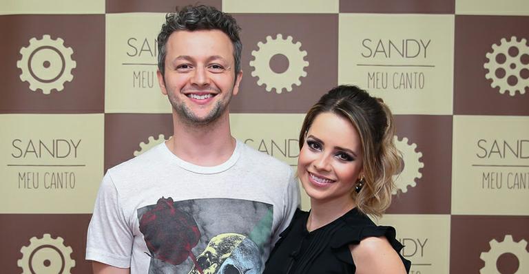 Sandy recebe o carinho do marido nos bastidores de show