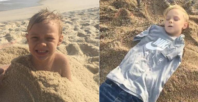 Que sono! Davi Lucca dorme enterrado na areia da praia