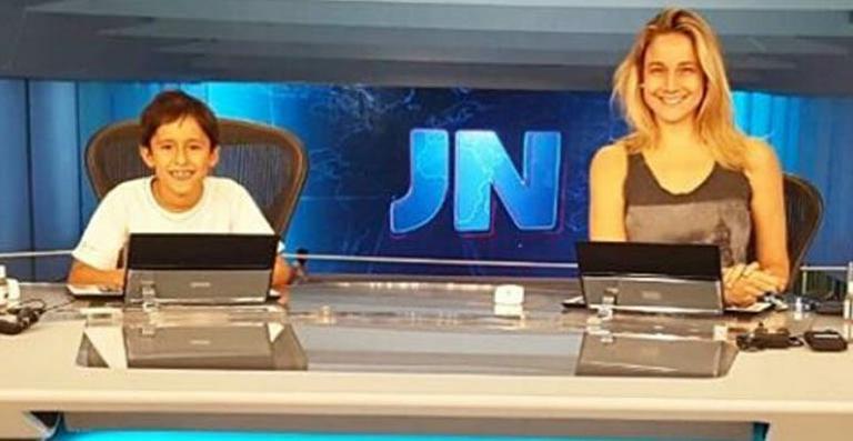 Fernanda Gentil visita o estúdio do Jornal Nacional com o afilhado