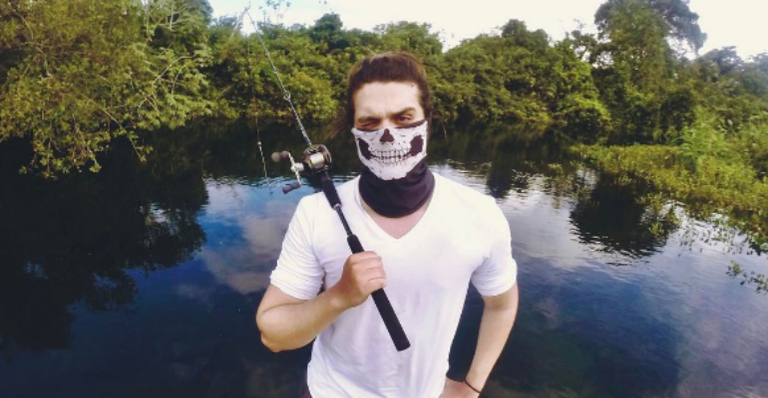 Luan Santana posa mascarado em rio no Pantanal