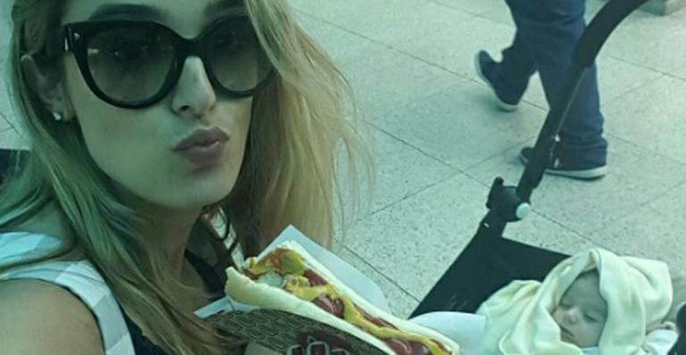Rafa Brites devora cachorro quente em aeroporto ao lado do filho