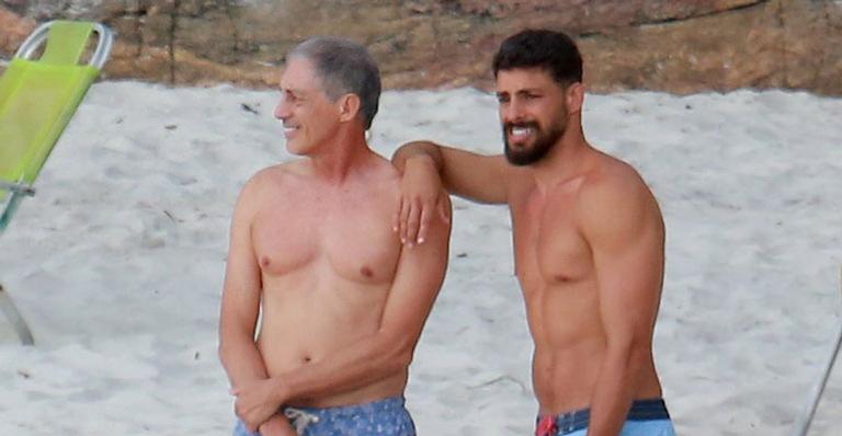 Cauã Reymond se diverte ao lado do pai e da filha na praia da Joatinga, no Rio