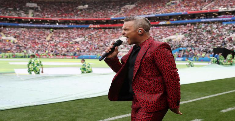 Descubra a grife responsável por assinar o look de Robbie Williams na abertura da Copa do Mundo