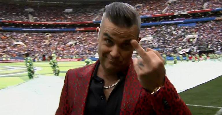 Usando terno extravagante, Robbie Williams mostra dedo do meio na abertura da Copa do Mundo