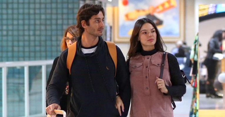 Grávida, Isis Valverde se diverte com o marido, André Resende, em aeroporto