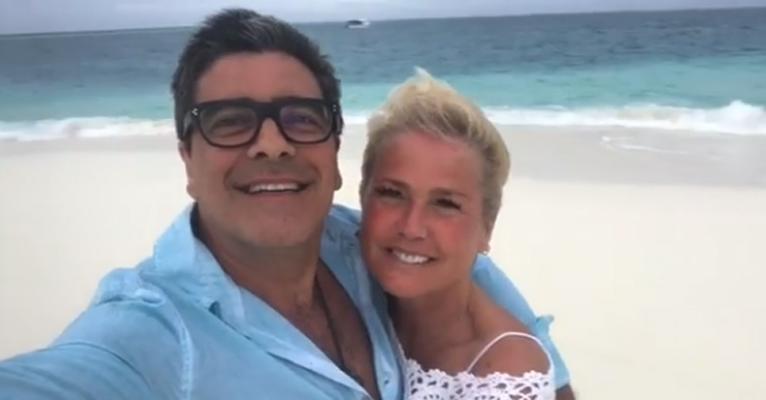 Xuxa e Junno Andrade trocam beijos e cantam juntos em praia paradisíaca