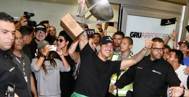 Gabriel Medina chega ao Brasil com troféu e causa tumulto no aeroporto