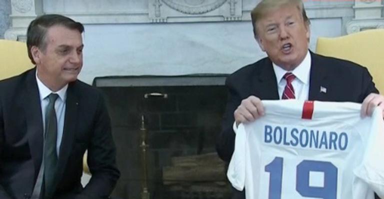 Bolsonaro recebe camisa improvisada de Trump: ”Por isso que não participo de amigo oculto”