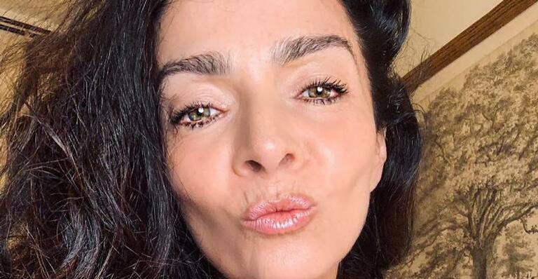 De camisola preta decotada, Claudia Ohana tira cliques sensuais na cama