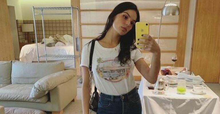Só de maiô, Isis Valverde empina o bumbum no sofá em dia de surfe