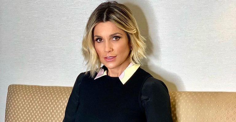 De cabelos longos e escuros, Flávia Alessandra surge em momento de gravação