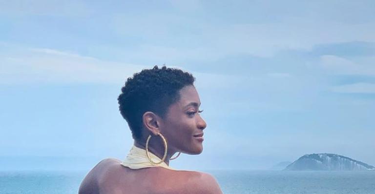 Erika Januza surge com as costas completamente nuas em paisagem paradisíaca e impressiona