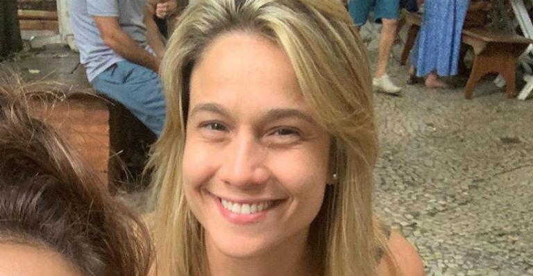 Fernanda Gentil aparece com sorrisão no rosto e um copo na mão e brinca: ”Queria estar assim”