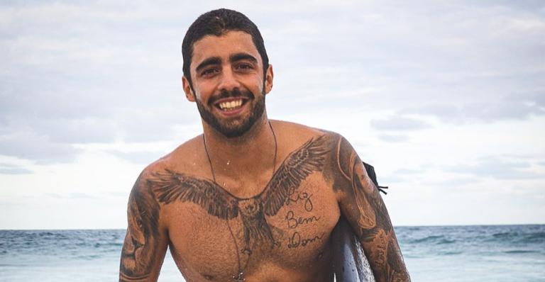 Descamisado e exibindo tatuagens, Pedro Scooby se diverte jogando bola na praia