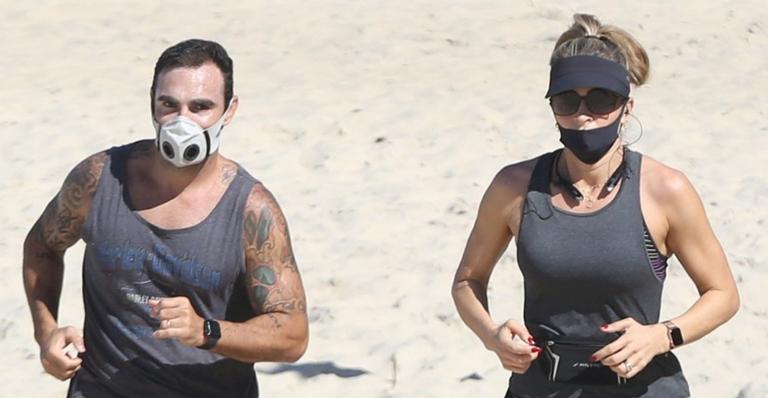 Na praia, Grazi Massafera corre com o personal Chico Salgado