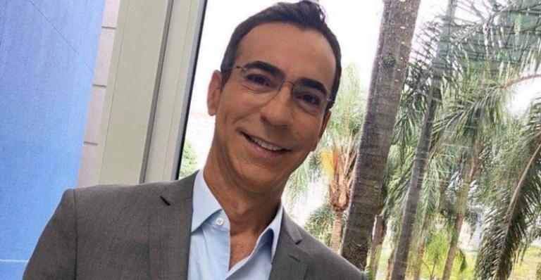 Com frio, Cesar Tralli posa no chão do estúdio com casaco emprestado: ”Que sexta gelada é essa”