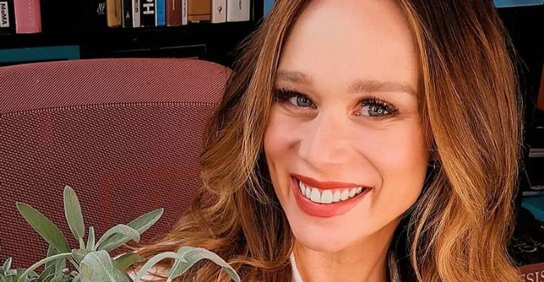 Mariana Ximenes surge de maiô decotado e tomando uma água de coco em clique nas redes