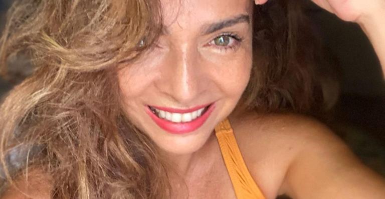 De biquíni, Claudia Ohana toma banho de Sol em casa e fãs elogiam: ”Essa mulher é que nem vinho”