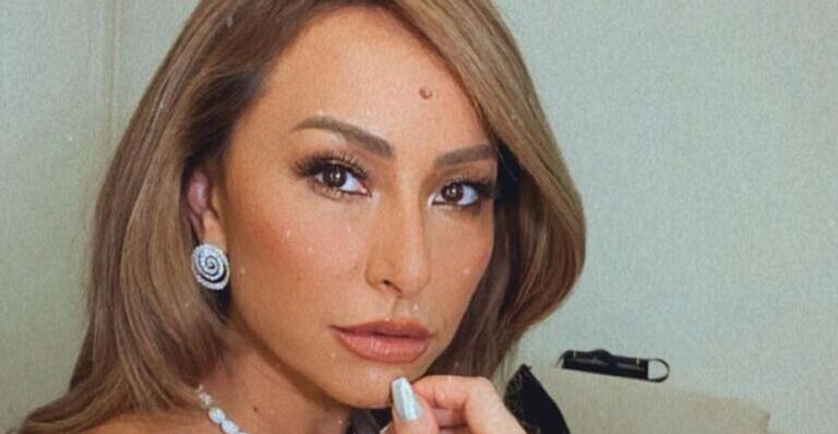 De vestido branco com plumas, Sabrina Sato ostenta bumbum empinado e pernas saradas