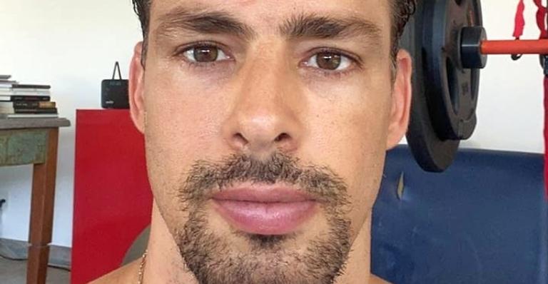 De camisa regata, Cauã Reymond posa deitado no sofá e brinca: ”Cochilinho”