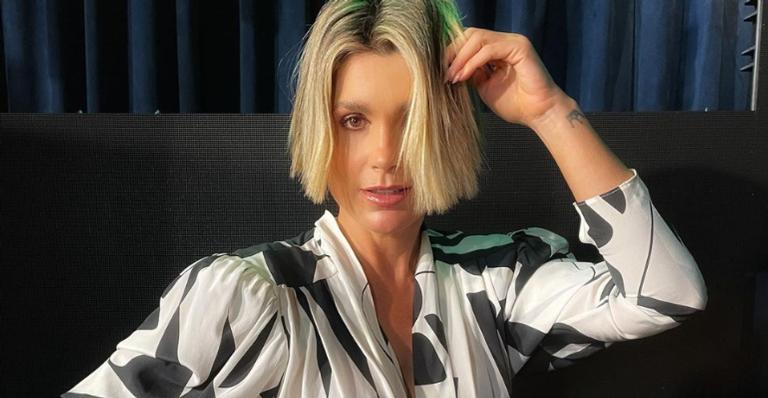 Flávia Alessandra brinca com seu reflexo no espelho e diz: ”À procura de uma gêmea”