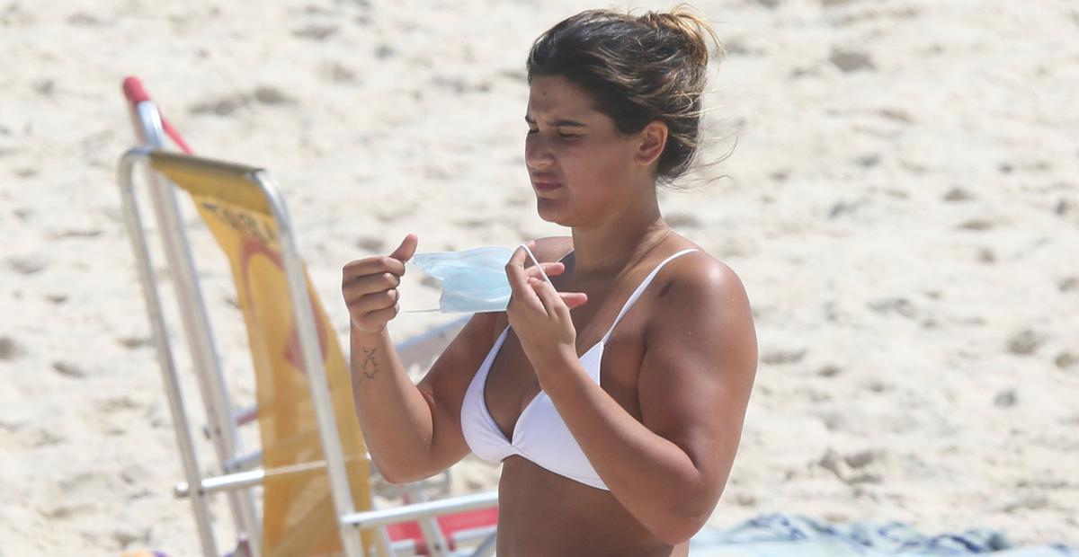 Giulia Costa renova o bronzeado com biquíni branco cavado e rouba a cena na praia