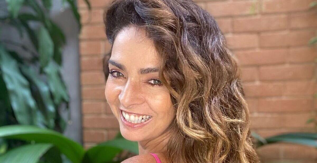 Aos 58 anos, Claudia Ohana surge só de lençol na cama e impressiona com beleza